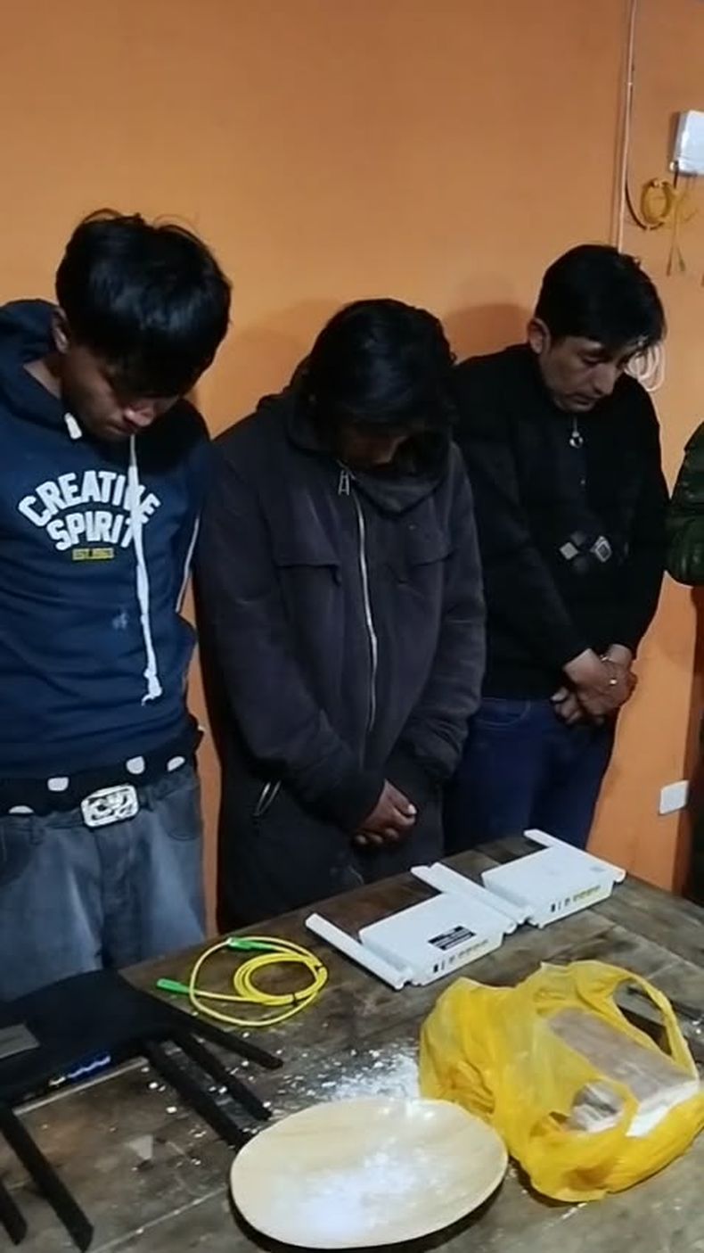 Tres de los cuatro presuntos integrantes de los Vatos Locos, aprehendidos durante un operativo militar en San Bartolo, sur de Quito, junto a parte de los indicios encontrados.