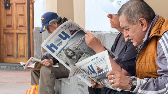 Tres ciudadanos leen la primera edición impresa de Diario HOY, luego de 12 años, el 12 de octubre de 2026.