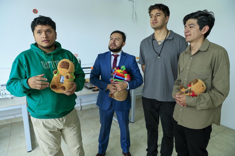 El estudiante de mecatr&oacute;nica Josu&eacute; Esp&iacute;n (i) junto a sus compa&ntilde;eros Mateo Fabara (c-d) e Israel Robayo (d), y su profesor e investigador Wilson Pav&oacute;n.