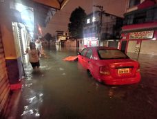 Un auto circula por una de las calles inundadas por la lluvias caídas en Guayaquil la noche del 23 de octubre de 2026.
