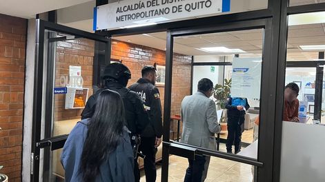 Funcionarios de Fiscalía y agentes policiales entrando al despacho de la Alcaldía de Quito para ejecutar un allanamiento.