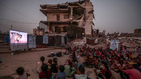 Niños ven una película en un cine montado al aire libre en el barrio de Al-Sheikh Redwan, en la ciudad de Gaza.
