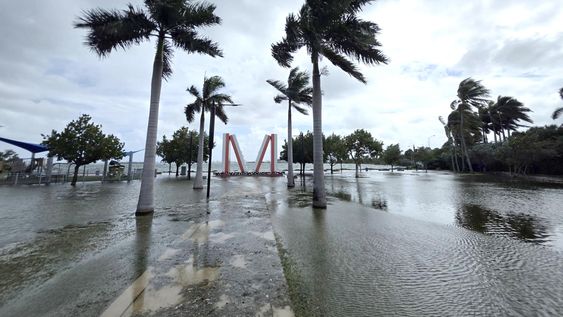 Fotografía que muestra las inundaciones cerca de la emblemática escultura gigante de una ficha de dominó ubicada en el parque Jose Milton este lunes en el centro de Miami, Florida.