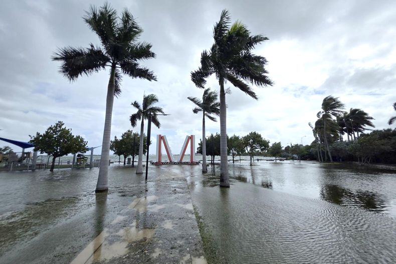 Fotografía que muestra las inundaciones cerca de la emblemática escultura gigante de una ficha de dominó ubicada en el parque Jose Milton este lunes en el centro de Miami, Florida.